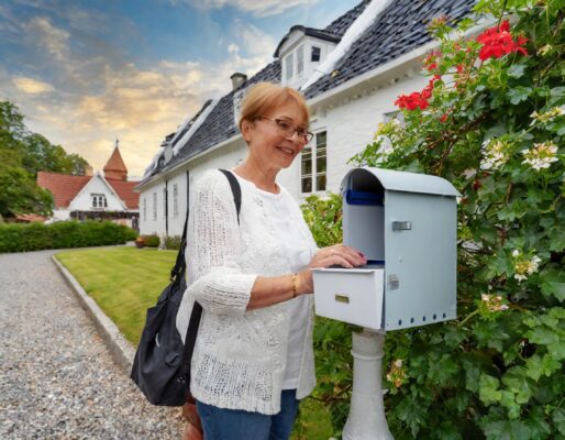 En dame på 50 år der tømmer sin postkasse ved sit hus i et villakvarter i slagelse.